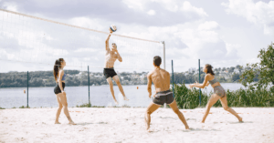 Ragazzi che giocano a beach volley in spiaggia