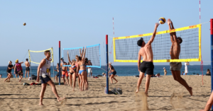 Gruppo di ragazzi che gioca a beach volley in spiaggia
